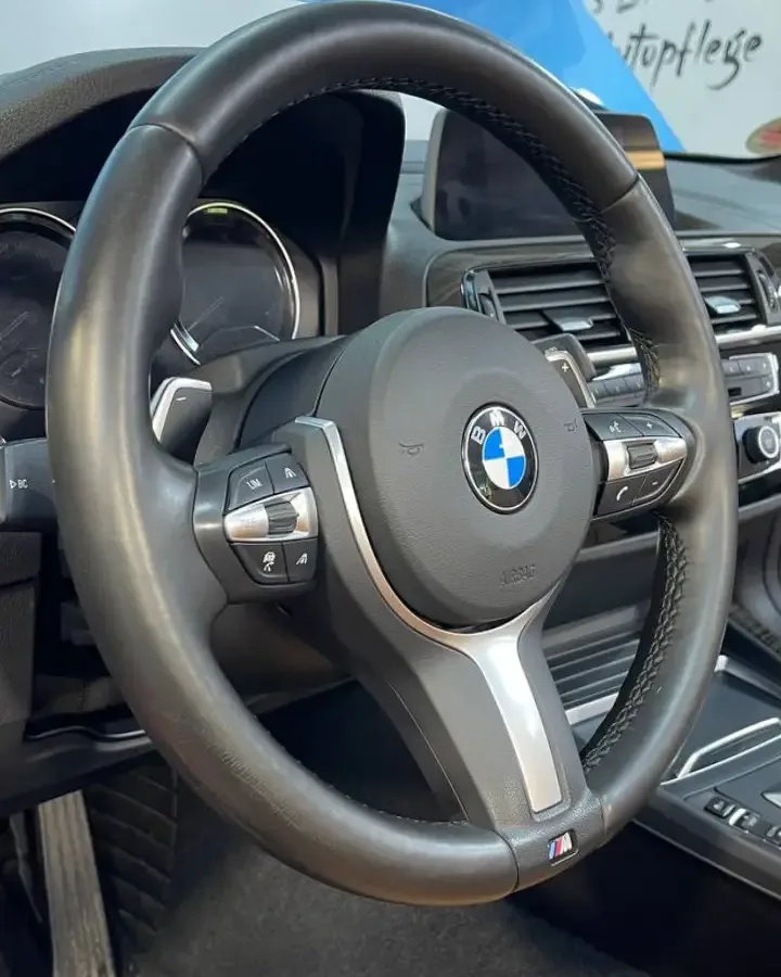 Gepflegtes, tiefschwarzes Lederlenkrad eines BMW M nach der Aufbereitung