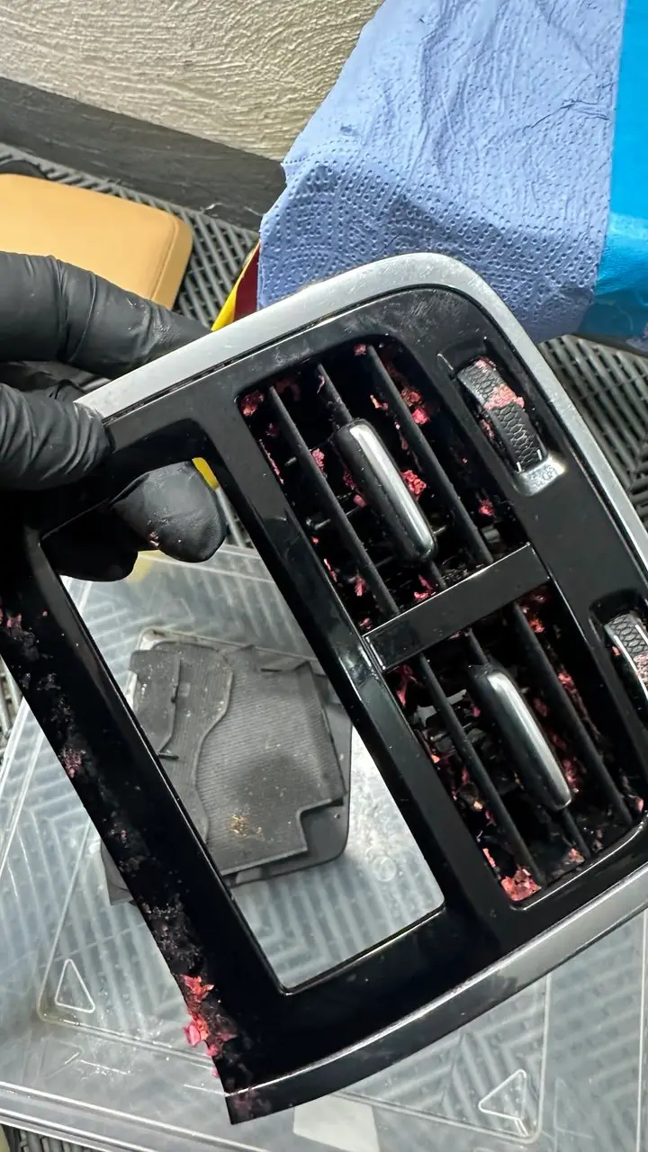 Ausgebaute Lüftungsdüse eines Volvo mit Schmutzresten in den Lamellen