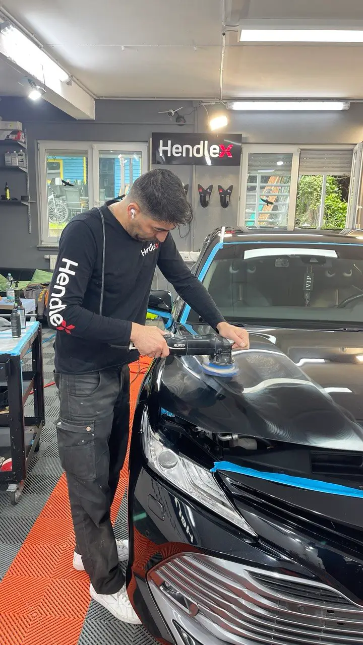 Mehrstufige Lackpolitur an einem dunklen Fahrzeug im Studio von Alex Autopflege in Schwelm